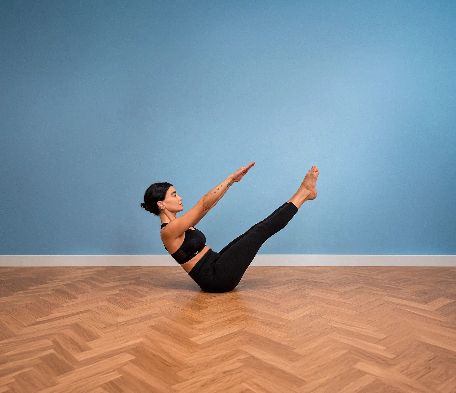 Sara practicando Pilates en posición teaser en el estudio Corpês